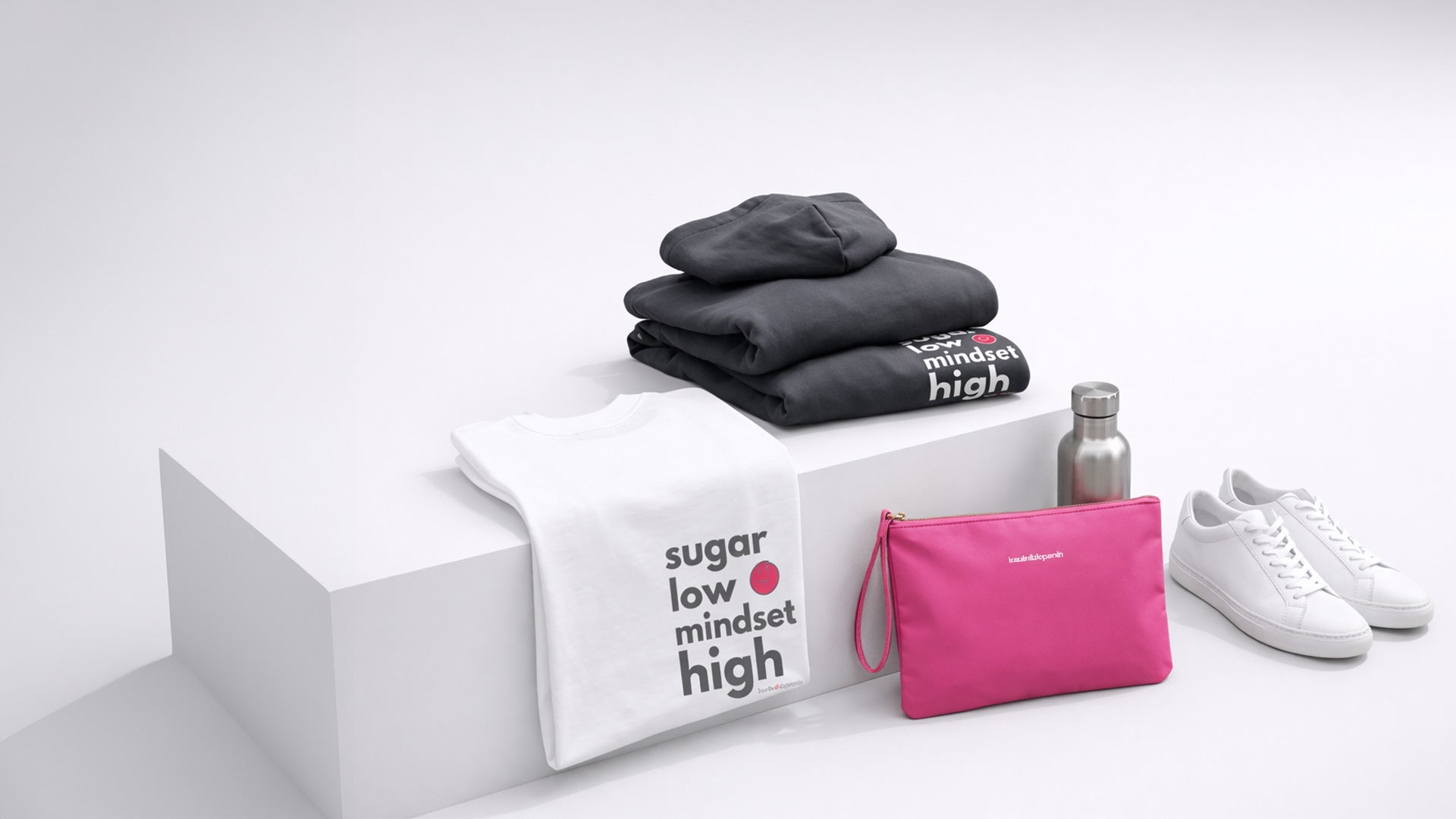 Eine Collage aus der Statement Kollektion von Insulin & Dopamin. Ein gefaltetes weißes T-Shirt, ein Schwarzer Hoodie und eine pinke Tasche